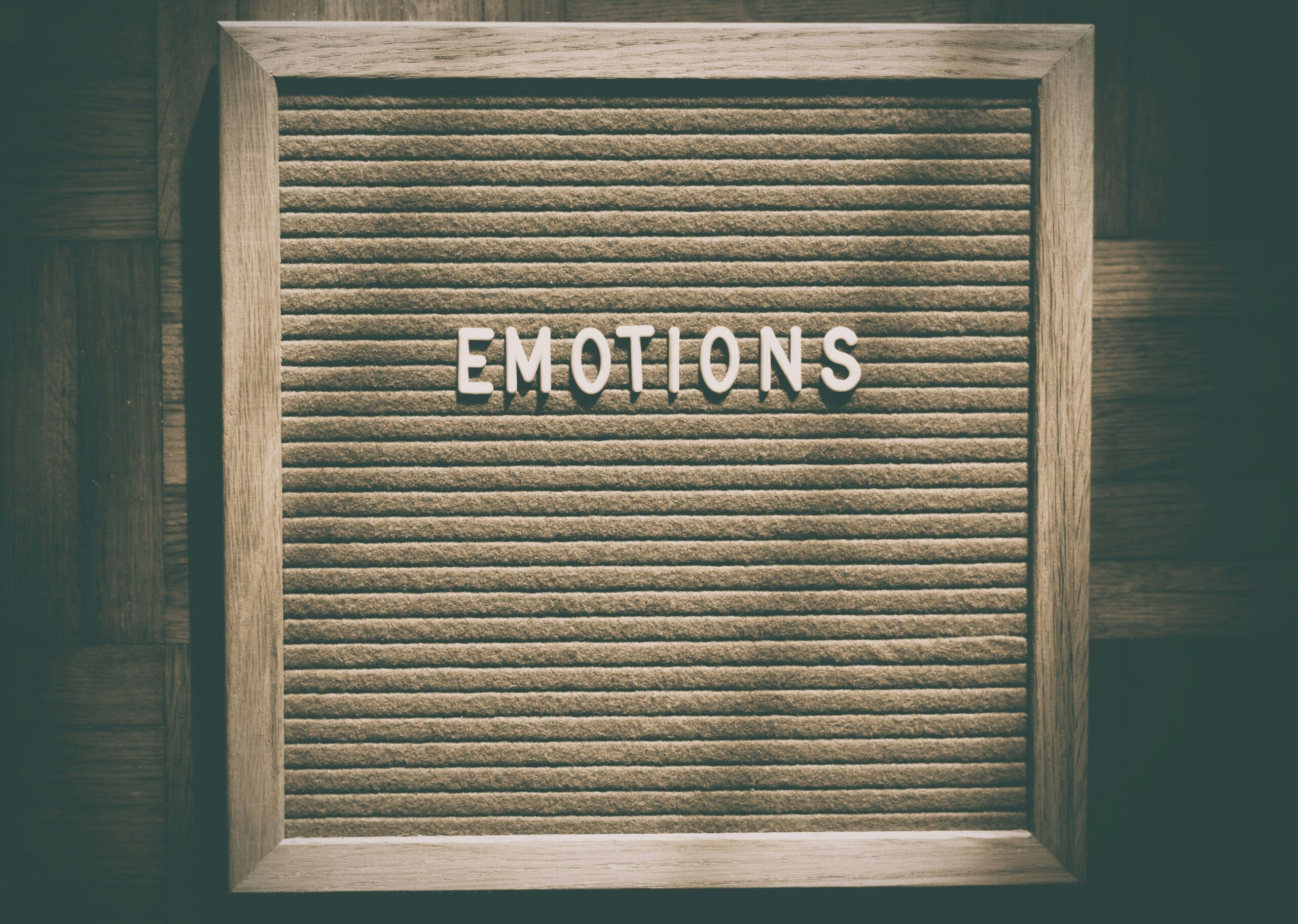 「EMOTIONS」と書かれたボードのクローズアップ写真。感情を閉じ込めたような静かな雰囲気。